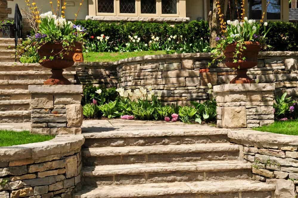 Tarzana, CA 1 Stone garden steps with potted plants, lush greenery, and a stone wall